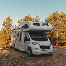white recreational vehicle parked in nature surrounded by trees ideal for road trips and outdoor adventures 4 unique features